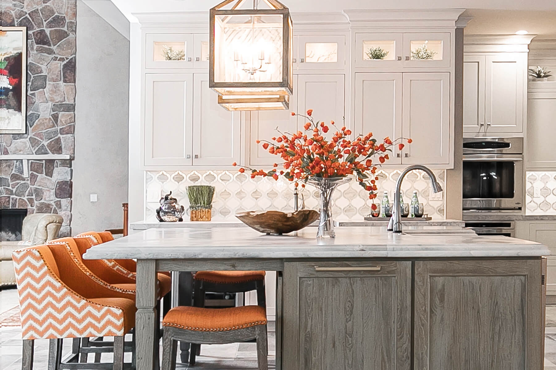 A classic white and gray kitchen with trendy orange accents.