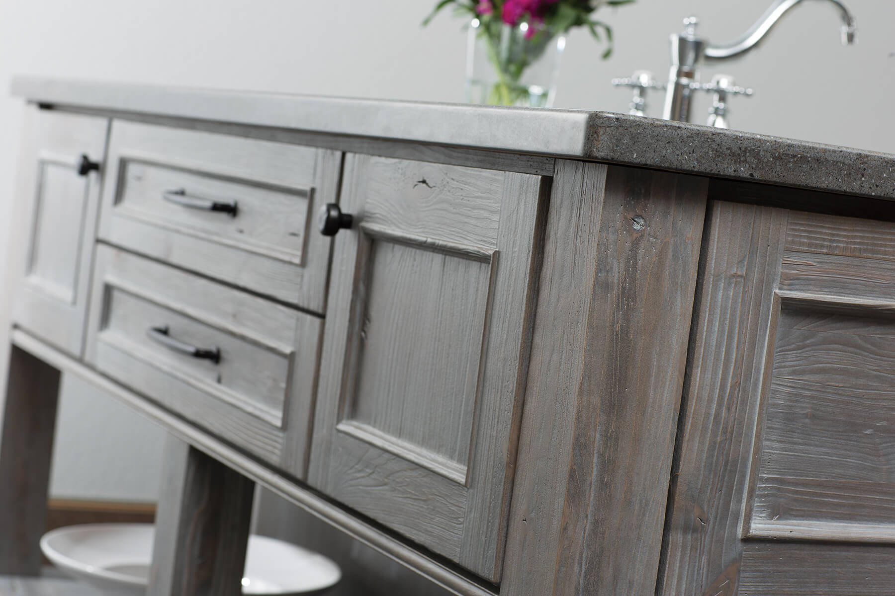 A gray stained kitchen island with weathered wood cabinets from Dura Supreme Cabinetry.