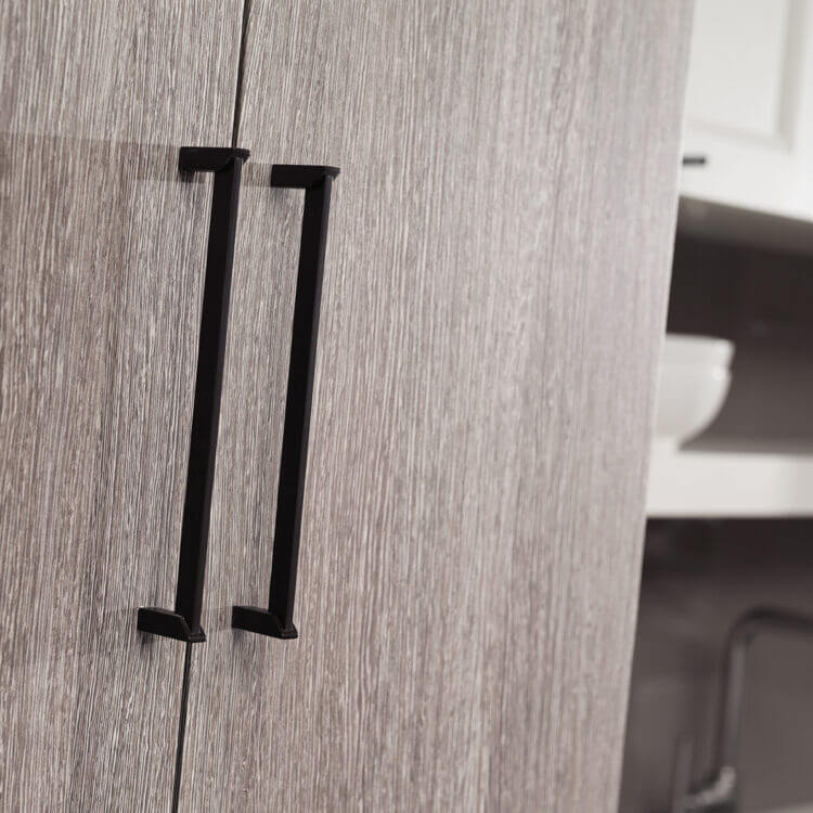A close up of slab cabinet doors with a textured foil material in a light gray with a straight grain pattern.