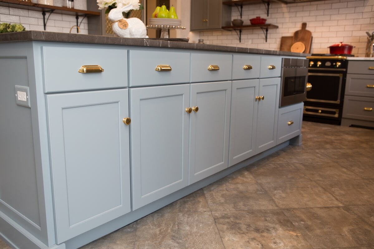 Kitchen island features Dura Supreme Cabinetry in the Kendall Panel door style in a blue custom color finish.
