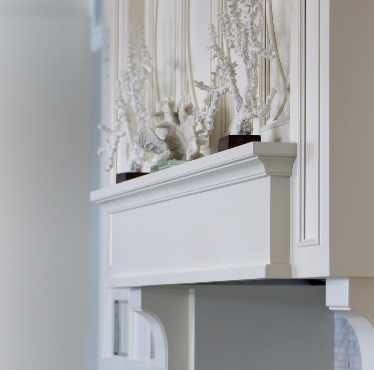 A beautiful wood hood with custom mullion details and a mantel shelf from Dura Supreme Cabinetry.