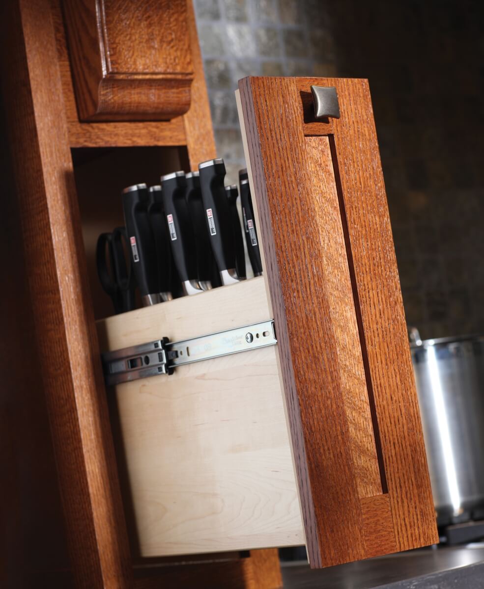 A pull-out cabinet hidden in the wood hood towers is designed to organize a full collection of cutlery in a knife block.