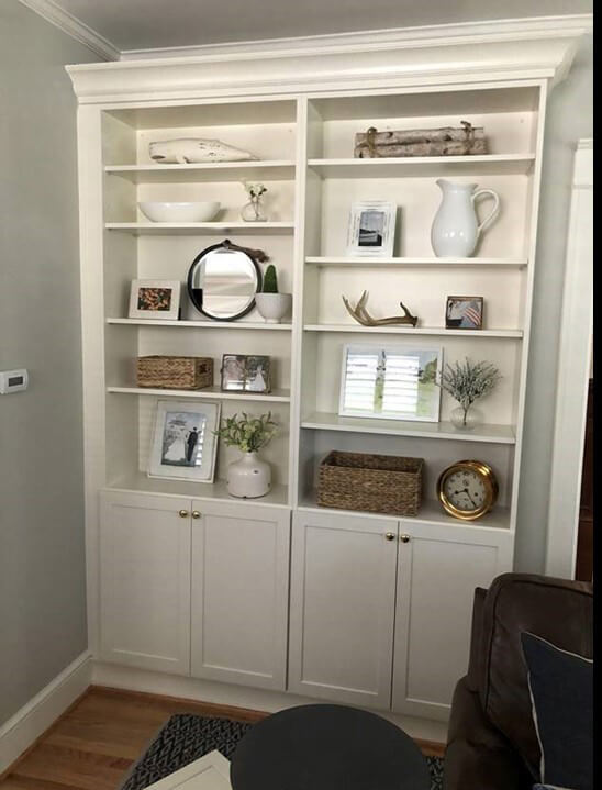A Classic White Dura Supreme Cabinetry bookshelf creates a lovely transition from the kitchen into the living room.