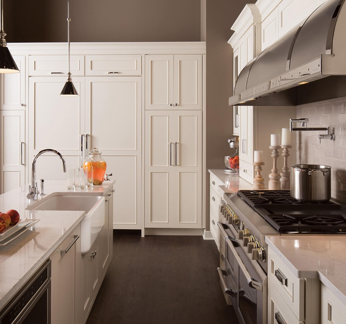 A kitchen storage wall with multiple pantry cabinets and Refrigeration featuring white painted Dura Supreme Cabinetry.
