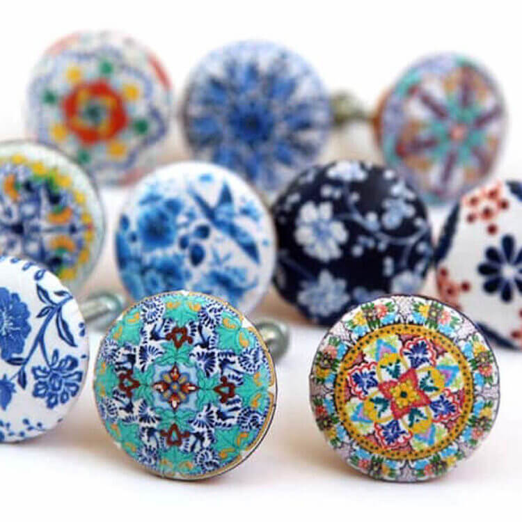 a close up of unique eclectic styled hardware for kitchen and bath cabinets with hand-painted designs.