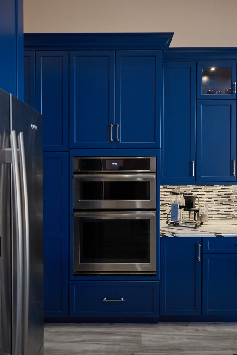 The Sherwin Williams Loyal Blue paint finish sets the stage for these flush inset oven appliances.