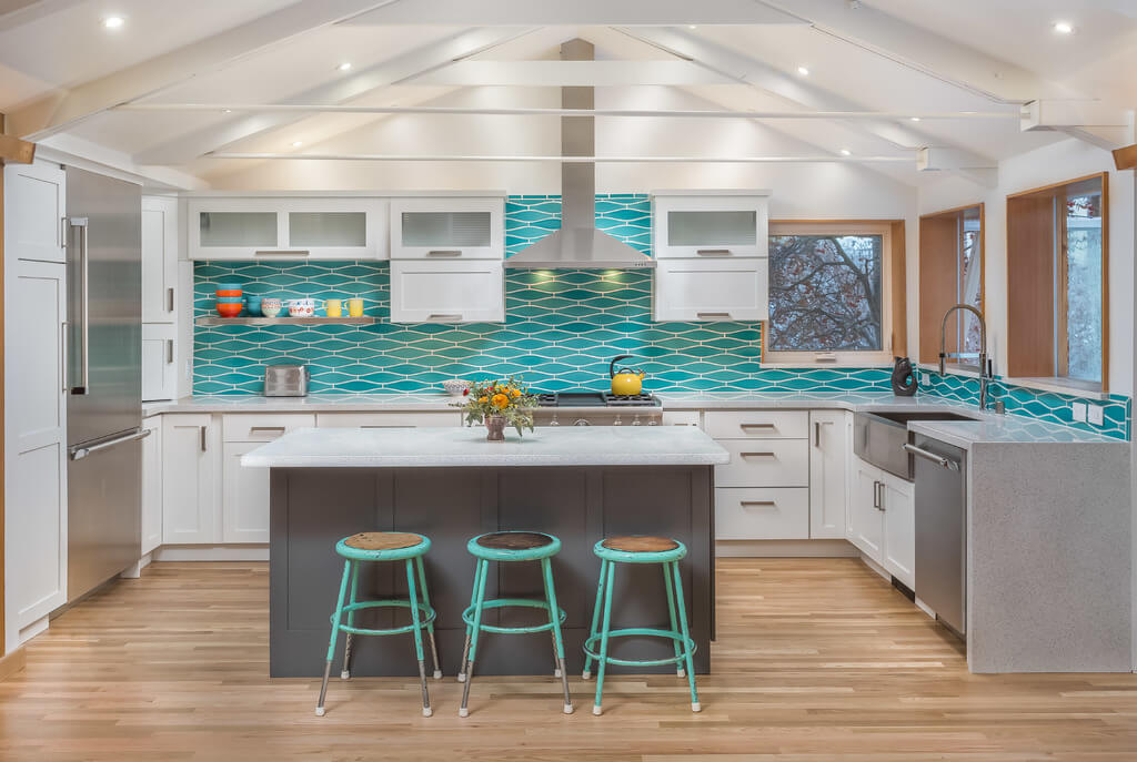A fun and colorful U-shaped kitchen with white painted cabinets from Dura Supreme and aqua blue tiled backplash.