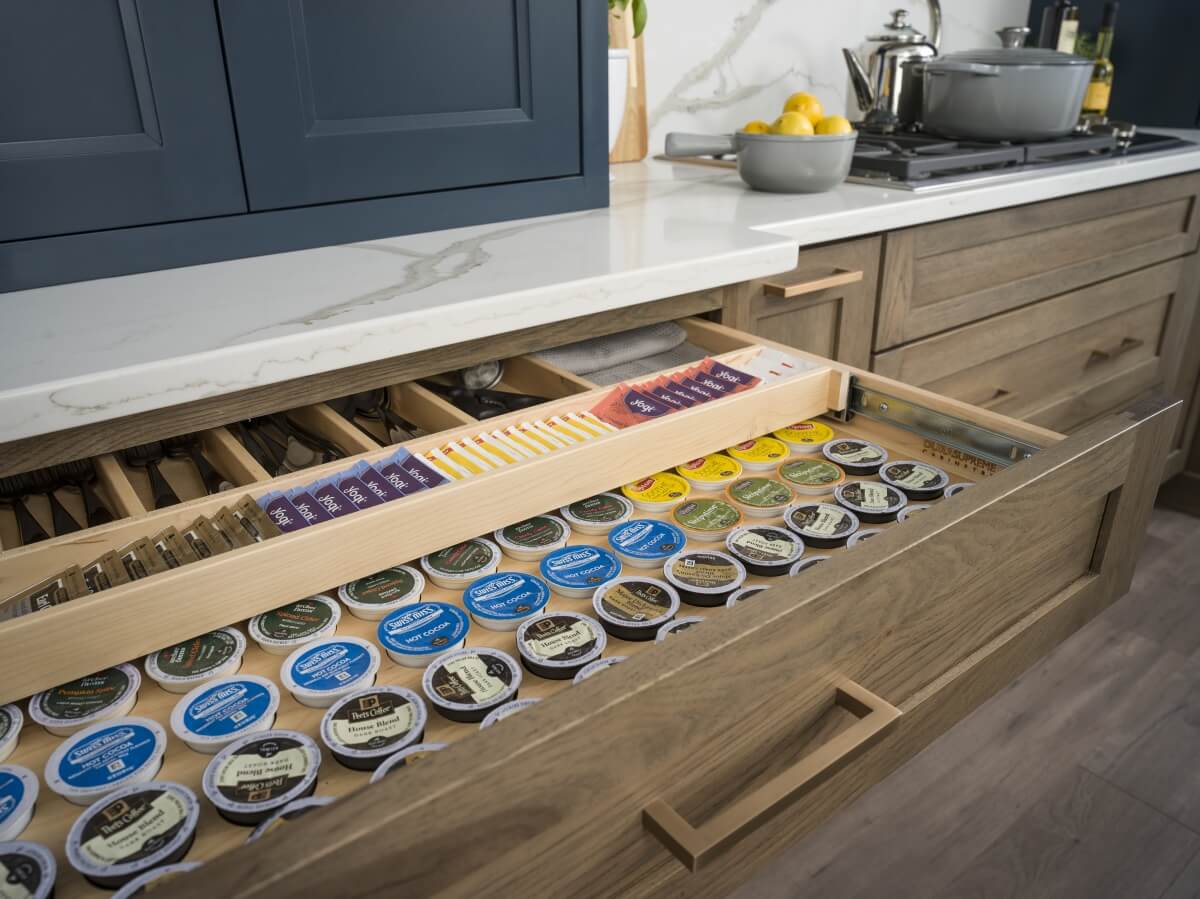 Two-Tiered Storage for K-cups, tea bags and drink supplies below Beverage Center from Dura Supreme Cabinetry