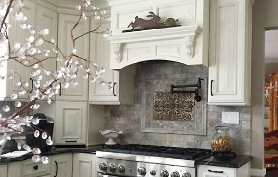 A white painted kitchen with a classic traditional wood hood.