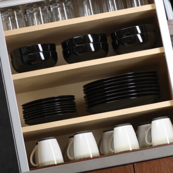 A tall cabinet provides centralized kitchen storage while adjustable shelves are precisely positioned for maximum organization of a large dishware collection.