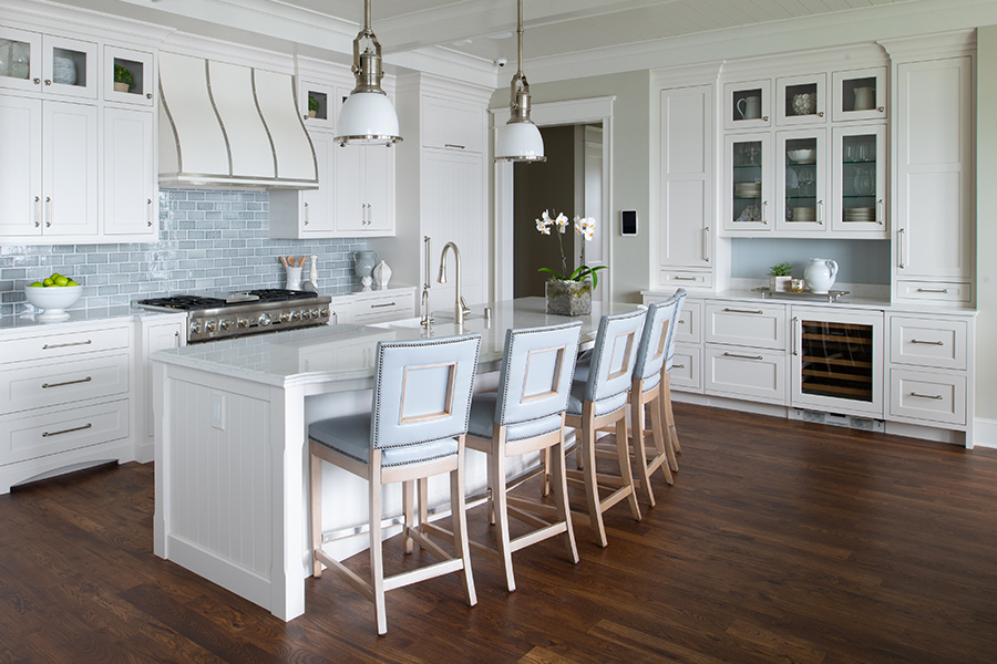 A quality kitchen cabinet brand. This Dura Supreme kitchen design features white painted cabinets with an East Coast Shaker style using V-Groove details that resemble the look of shiplap for the kitchen cabinet doors and kitchen island decorative end detail. See the cabinet review of this homeowners experience with Dura Supreme.
