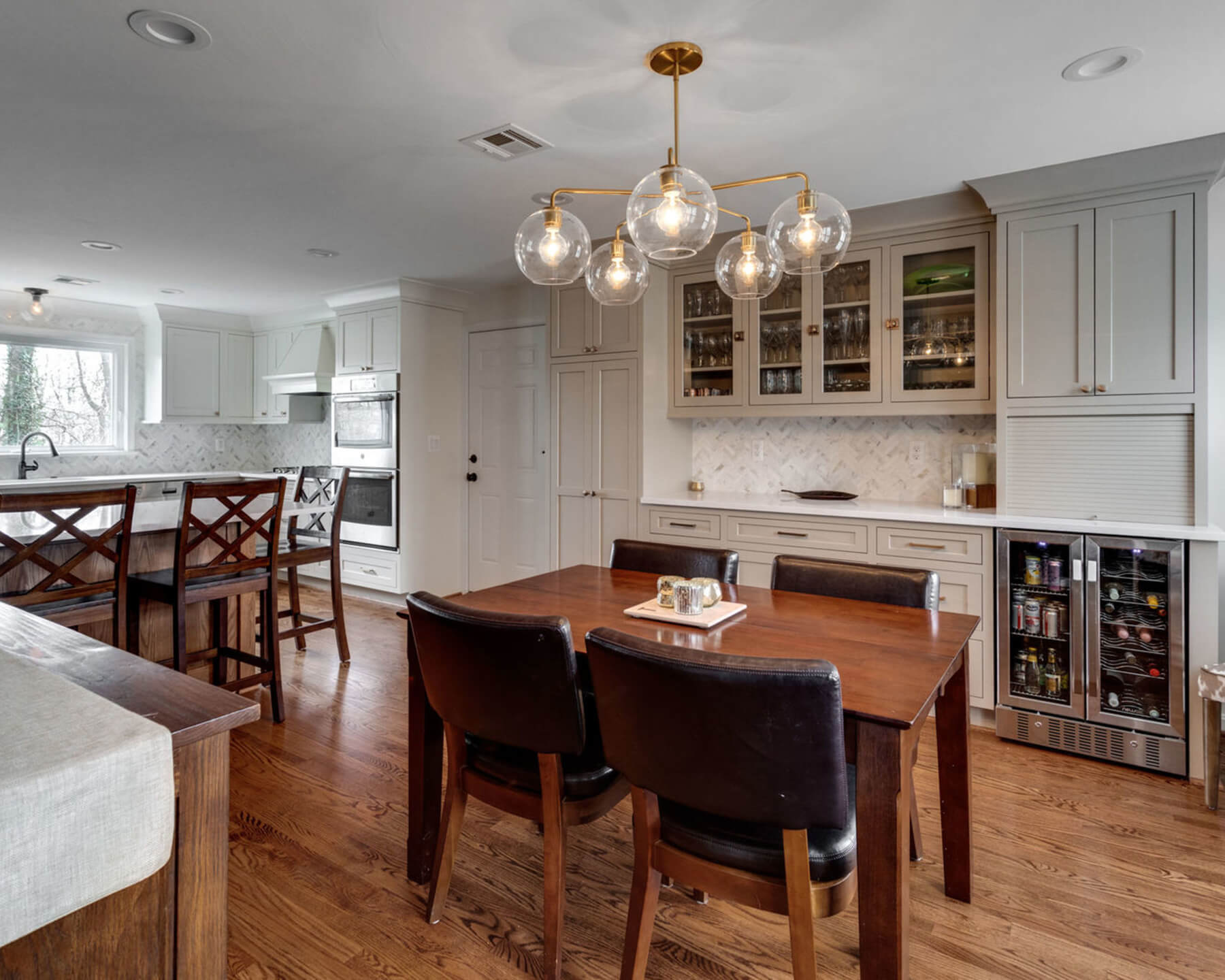 An eat-in kitchen that has peninsula cabinets to divide the space into two areas.