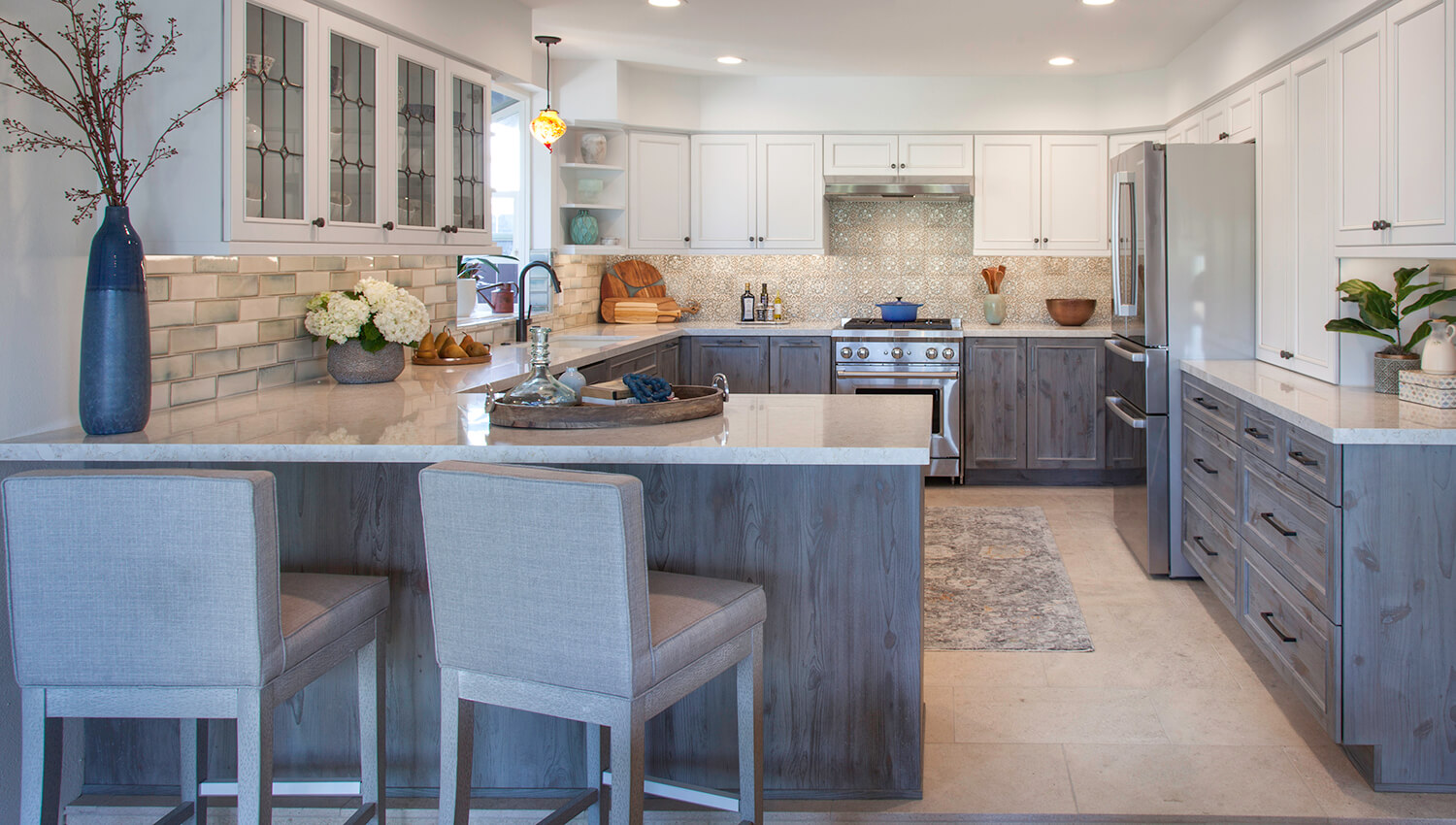 Peninsula in kitchen with weathered wood cabinets for the base cabinets and white painted cabinets for the wall cabinetry and wood hood.