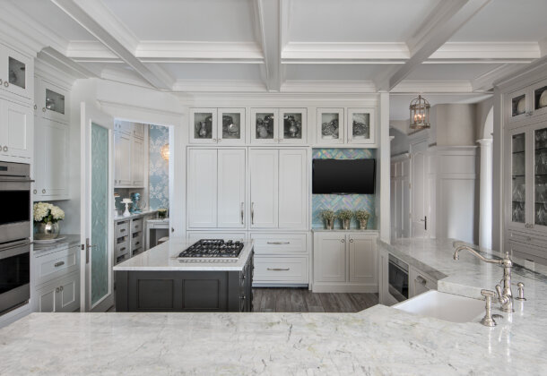 A glamorous all white kitchen design with white painted and gray stained cabinets.