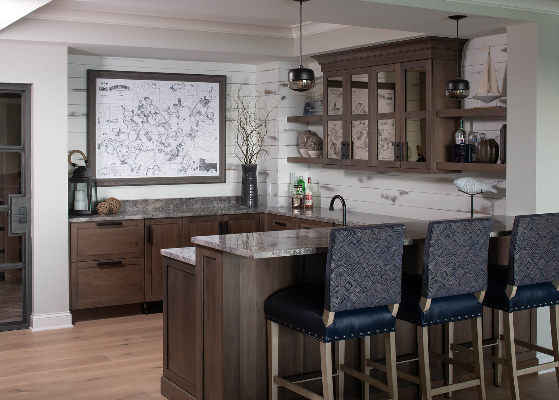 A u-shaped rustic home bar in a Minnesota lake house with a two-level peninsula for bar stool seating.