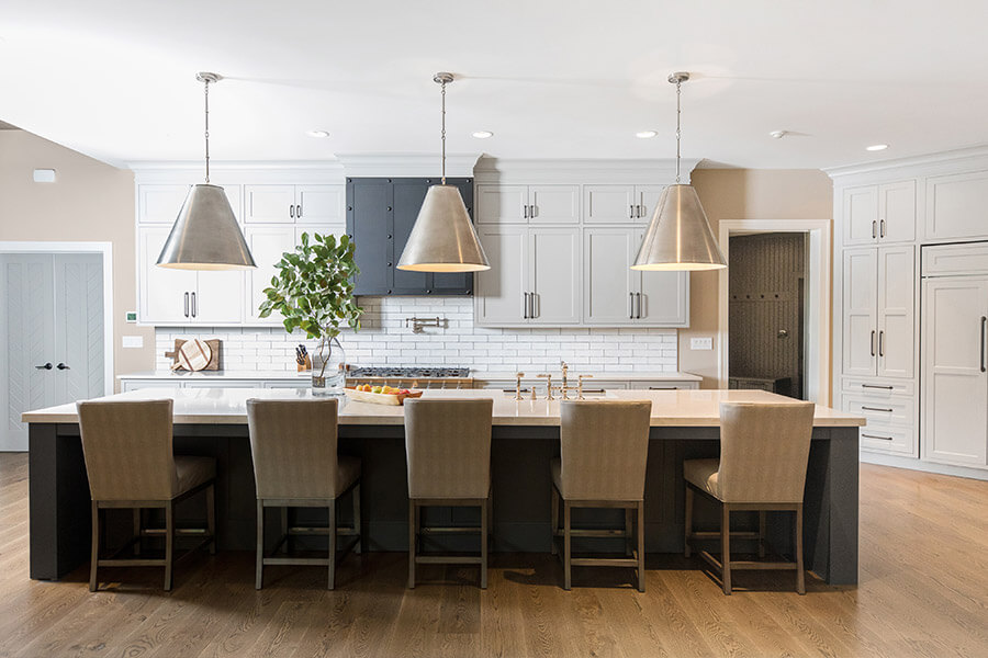 Learn how to create a variety of kitchen design styles. This modern farmhouse kitchen has a grand kitchen island with a dark gray stain while the perimeter cabinets are painted white. The architectural details that are less ornate and more subtle than traditional designs but are not as minimalist as contemporary. Transitional styling is not ornate or over-detailed, nor is it high-gloss and ultra-contemporary.