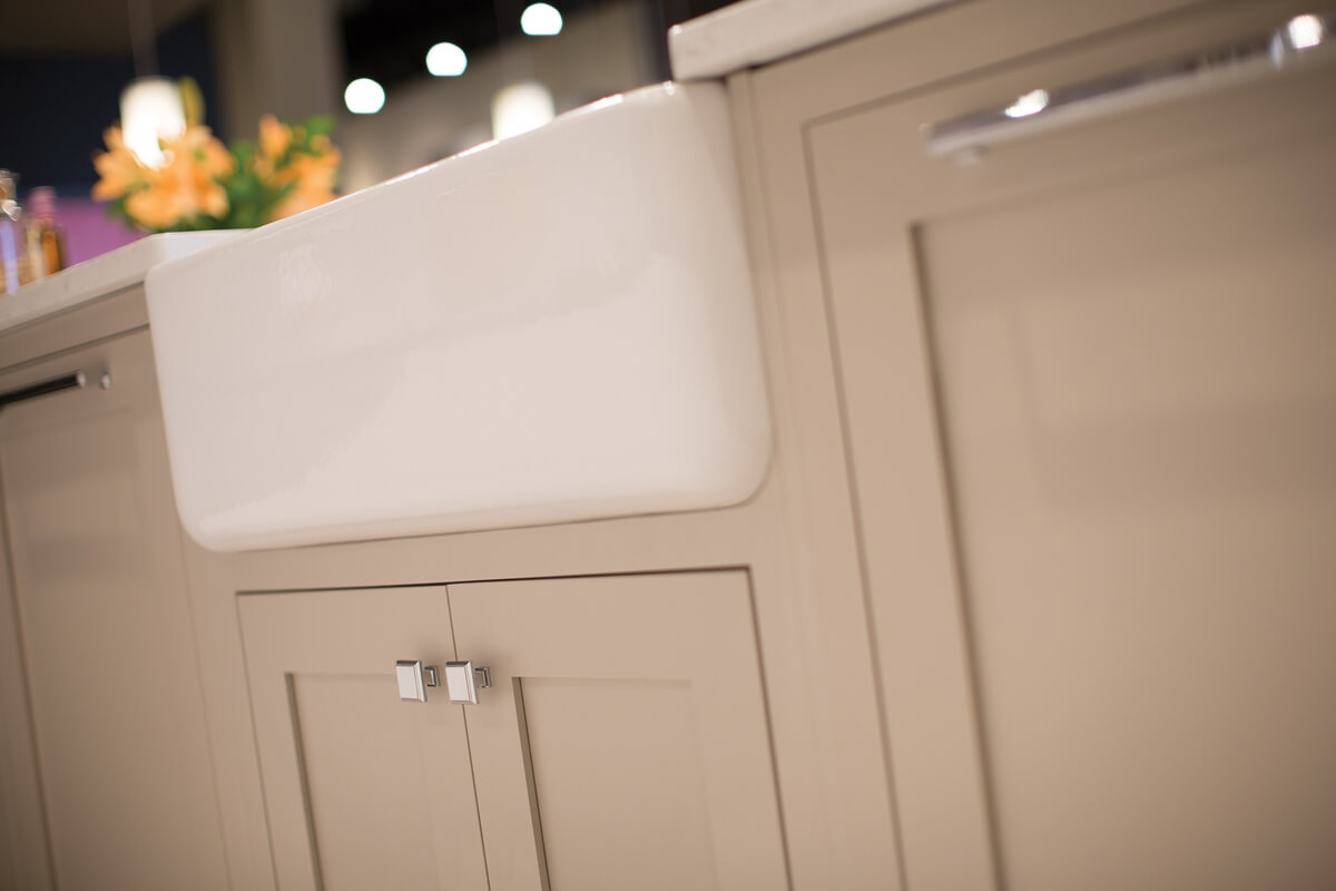 A close up of a beige or tan colored kitchen island from Dura Supreme Cabinetry with inset cabinet doors.