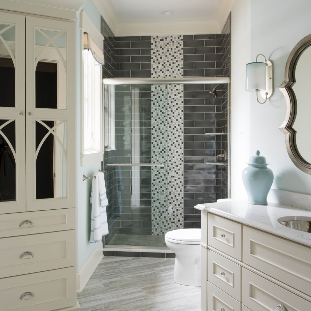 A stunning all white master bathroom with beautiful mullion cabinet doors with mirror glass inserts.