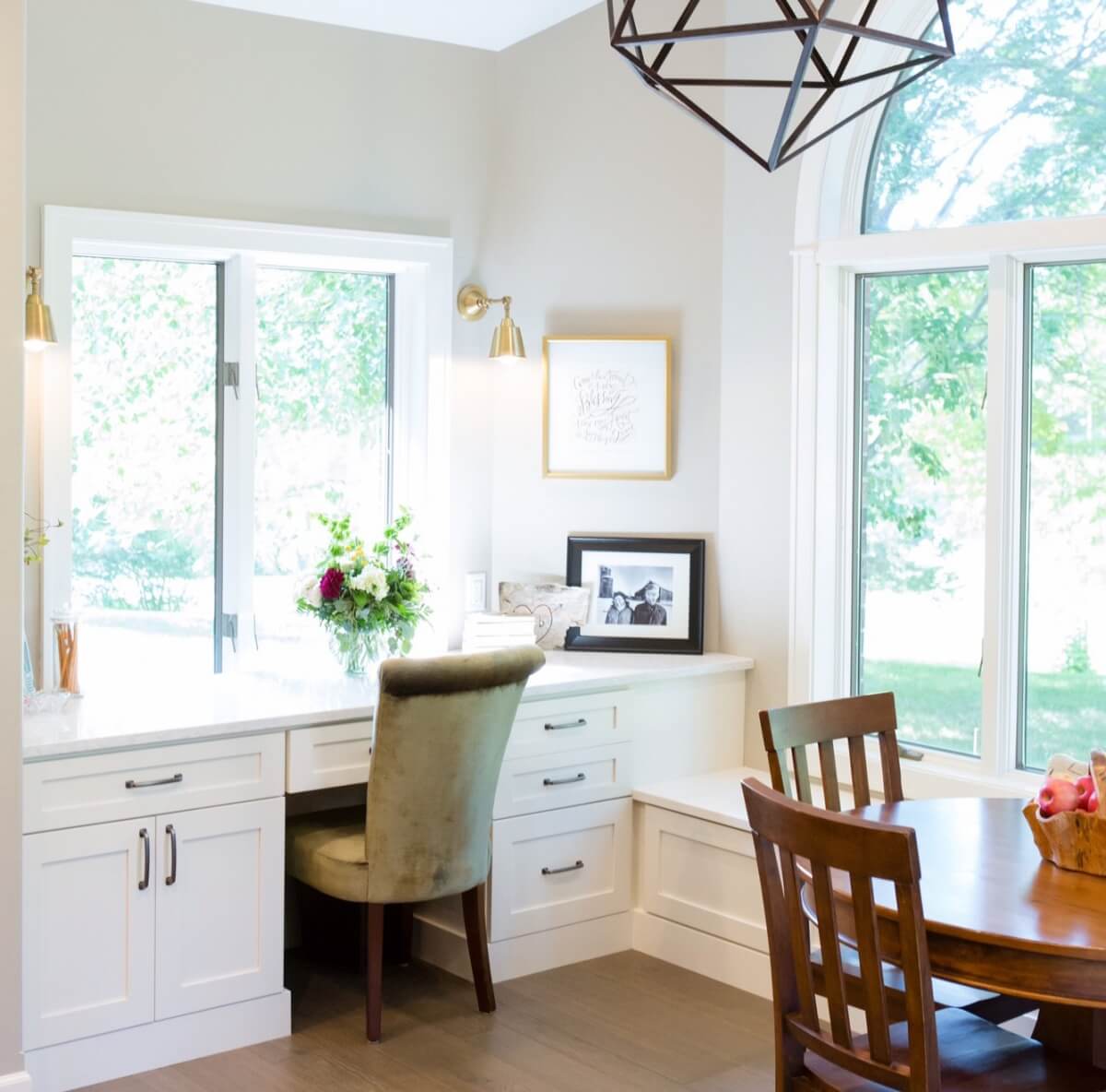 A stunning home office in the diining room with white cabinets and home office desk.