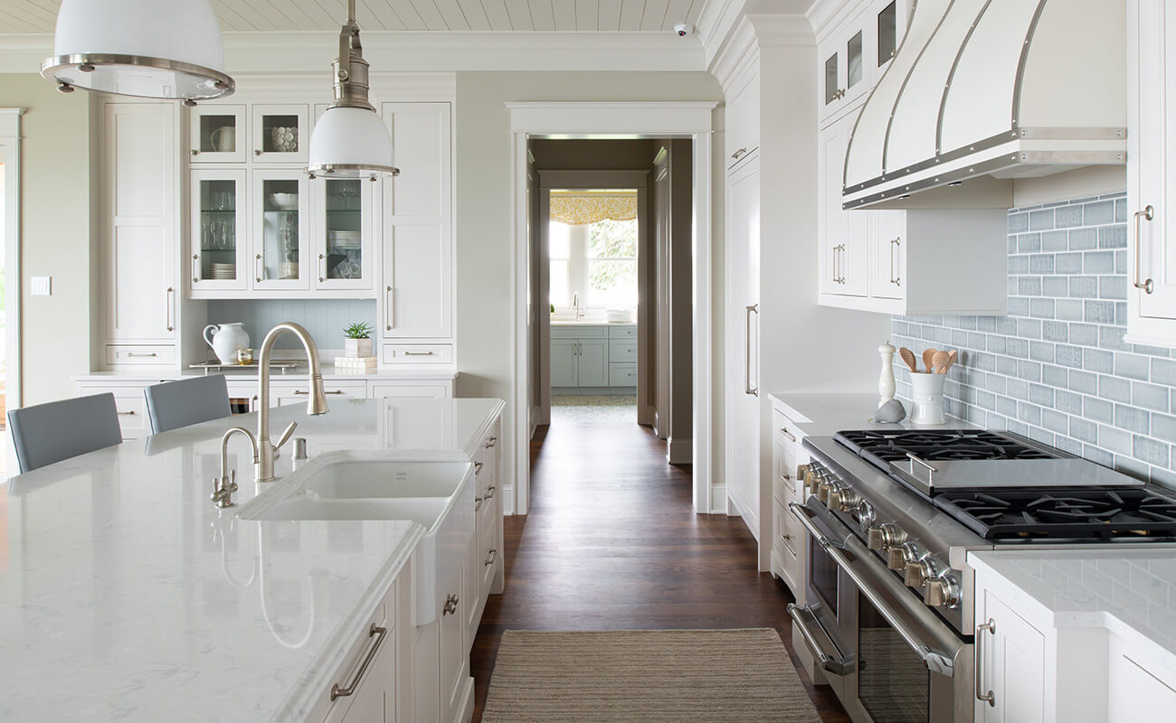 A coastal style kitchen with all-white finishes including white kitchen cabinets with American Framed construction.