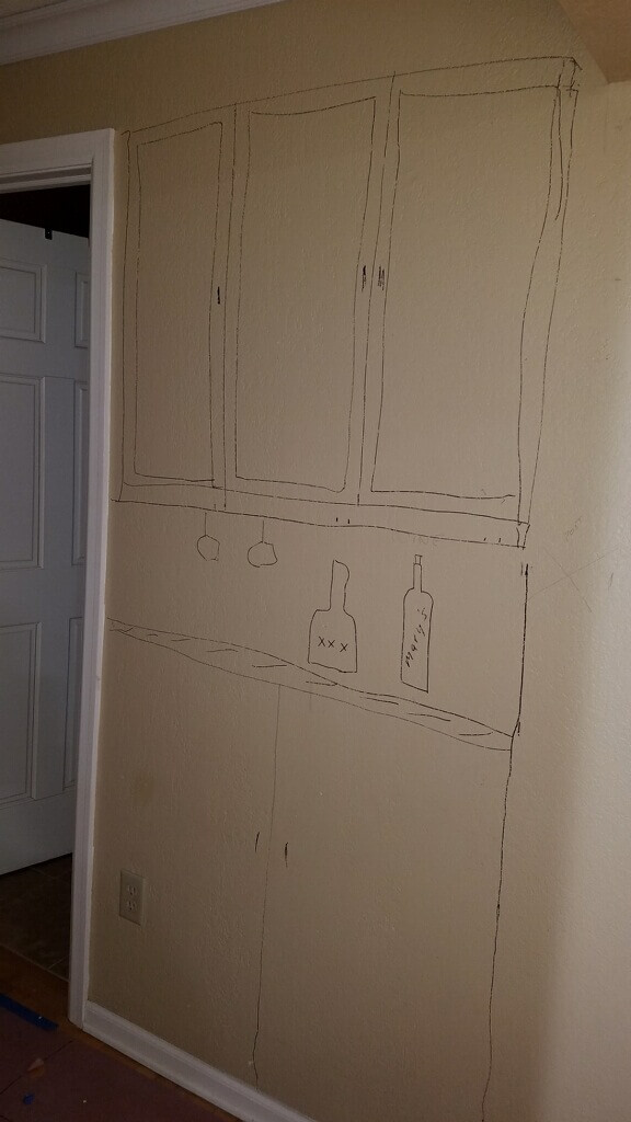 Before image of the wet bar remodel in the hallway. The designer drew on the wall to show where the cabinets and countertop will go.