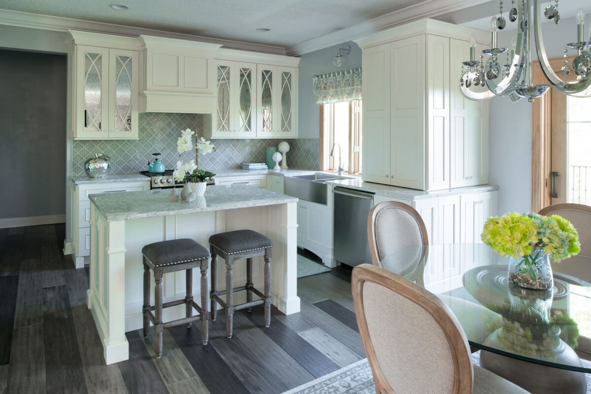 A bright white and reflective kitchen design with antique mirror cabinet doors.