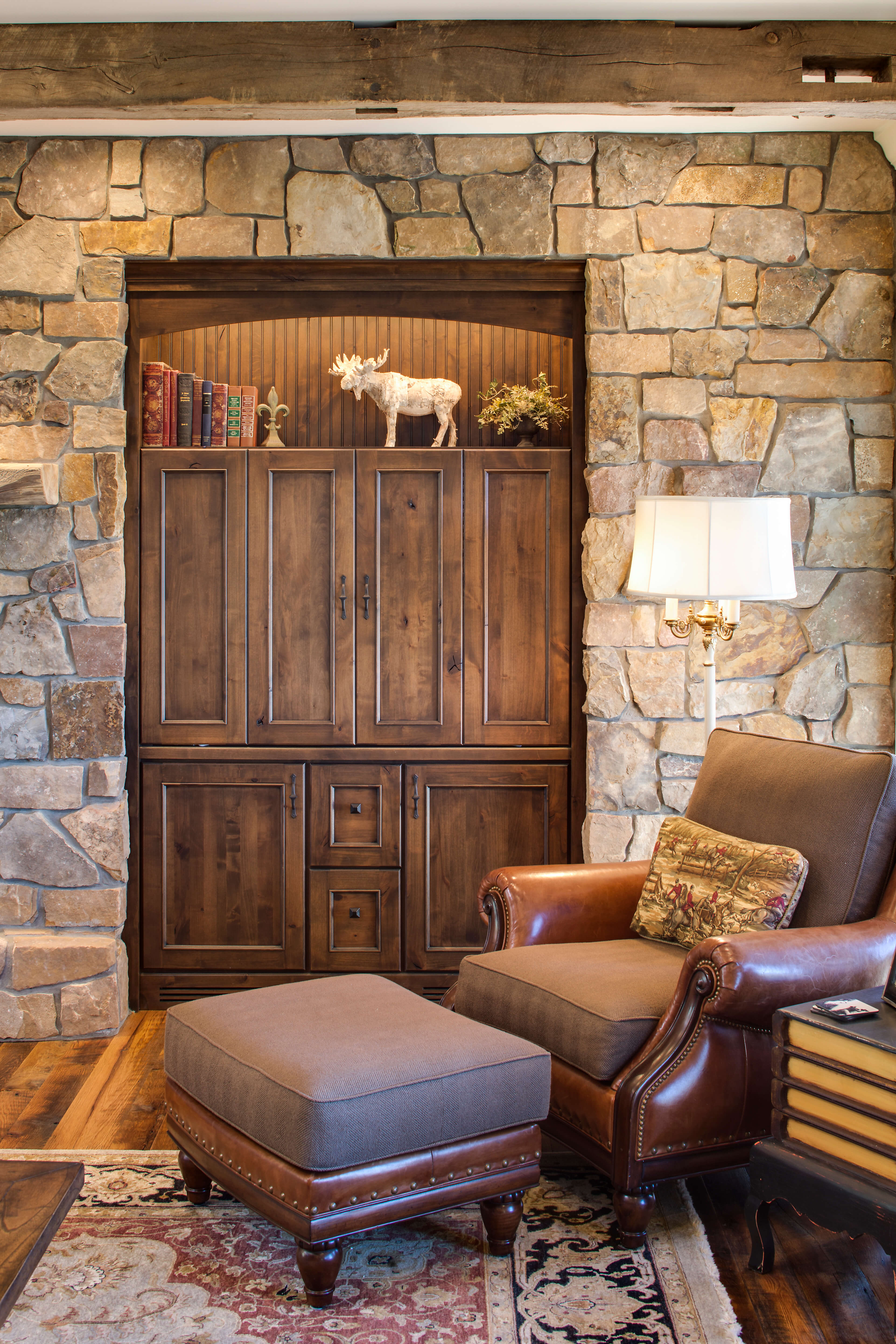 Rustic Knotty Alder Cabinets tucked into a stone wall for additional cabinet storage in a living room.