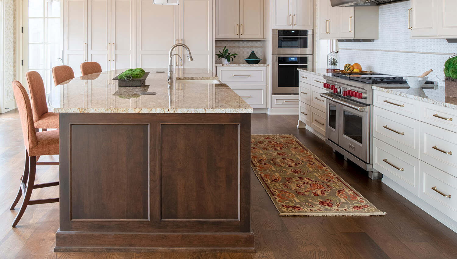 The kitchen island features a darker true-brown stain, Mocha on Cherry wood that beautifully contrasts the off-white perimeter cabinets shown in a Personal Paint Match to Benjamin Moore's Muslin paint color. 
