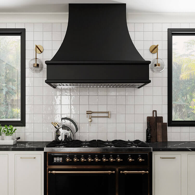 Modern curved wood hoods are a new product from Dura Supreme Cabinetry. This modern farmhouse kitchen features a black painted curved hood with a modern style.