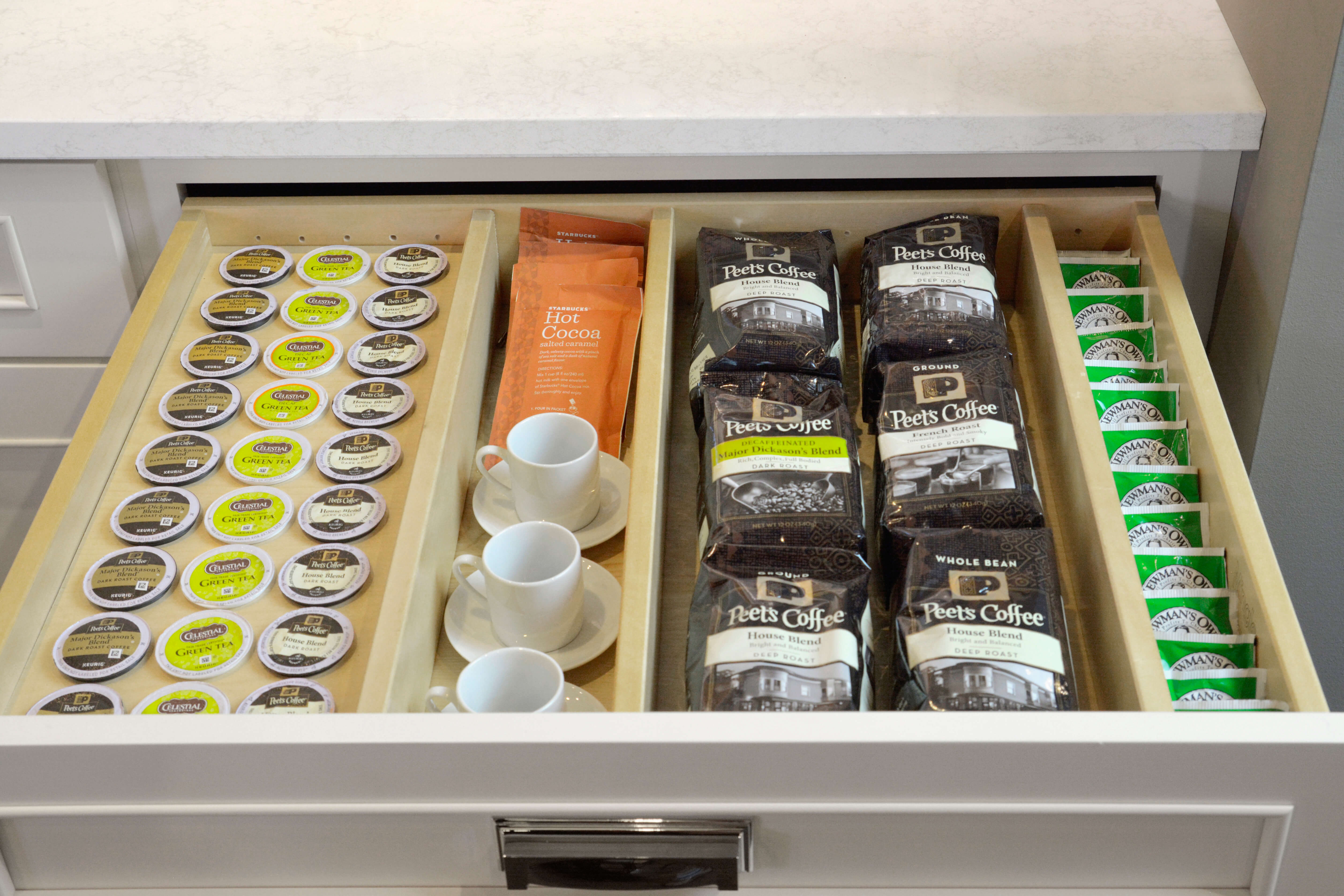 A kitchen drawer with accessories for organizing k-cups and coffee making supplies.