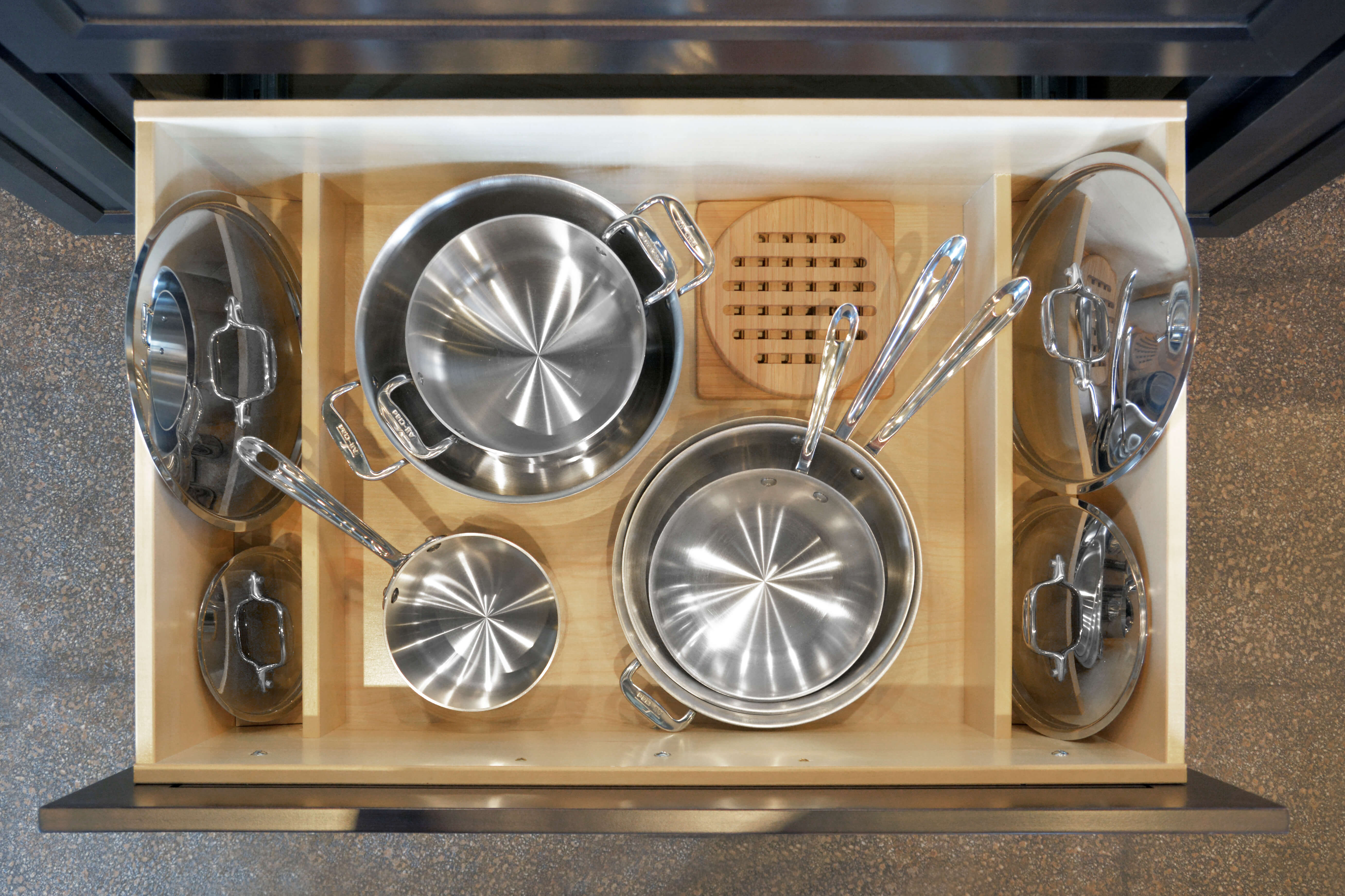 Lid dividers are built into the sides of a deep drawer for pot & pan Storage. Find kitchen storage solutions for pots & pans and organize lids with Dura Supreme Cabinetry accessories.