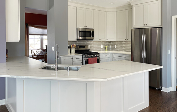 A kitchen cabinet review of new Dura Supreme cabinets in an all white themed kitchen renovation with an angled peninsula.