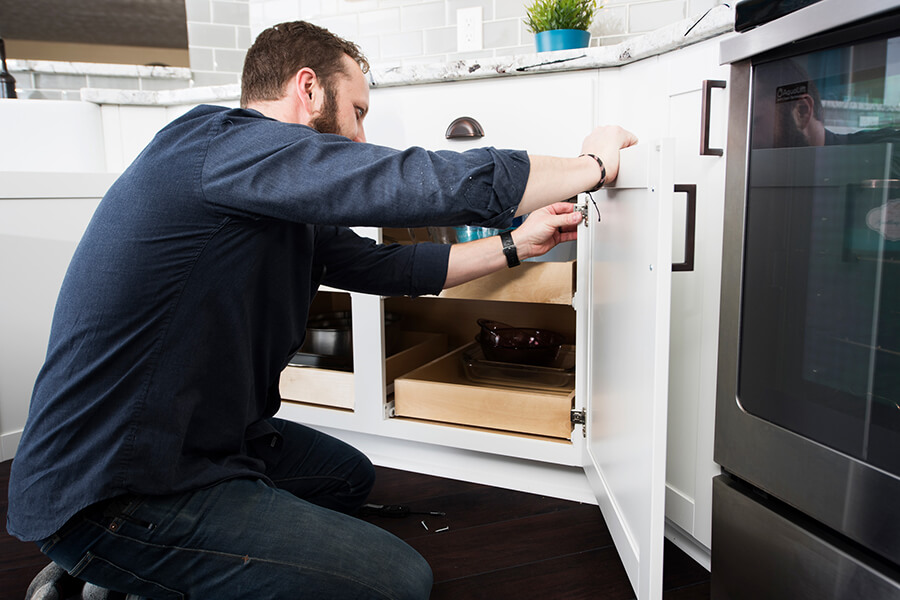 Cabinet installer adjusting the cabinet doors in a base cabinet.