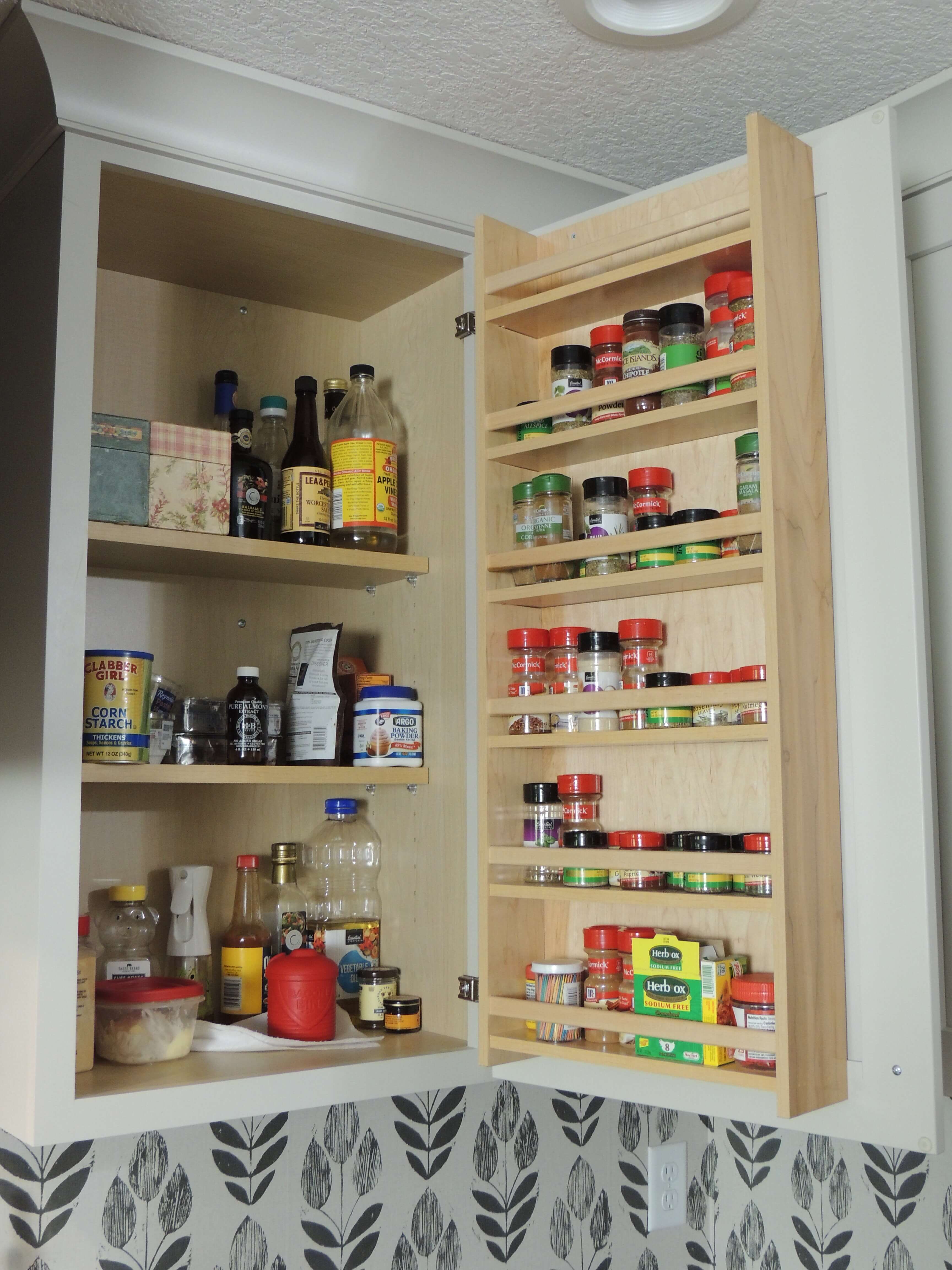 The cabinet door spice rack organizes an entire collection of spices and neatly displays them in a wall cabinet.
