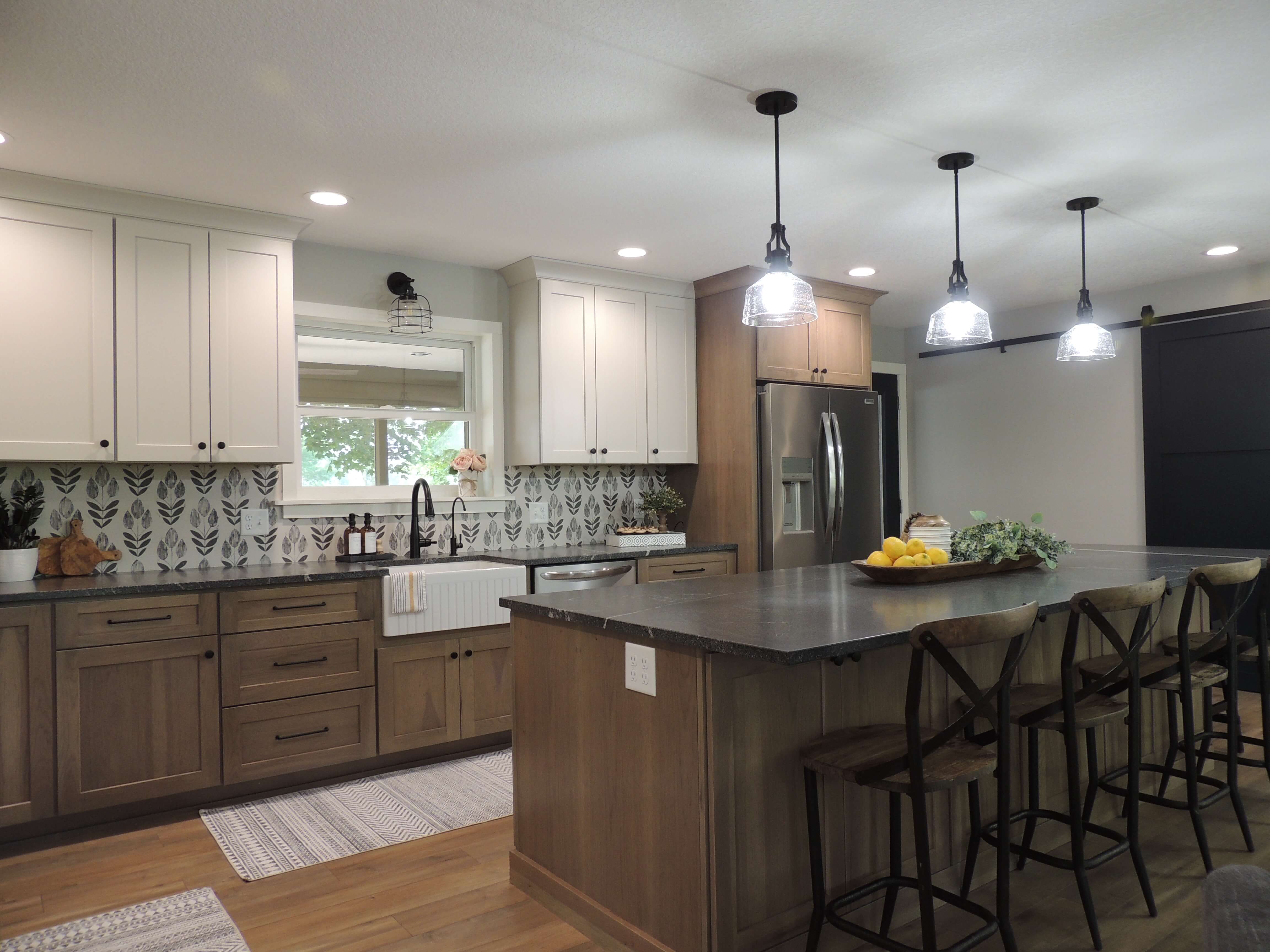 A pretty kitchen remodel with two colors of kitchen cabinets mixing stained wood and soft painted finishes.