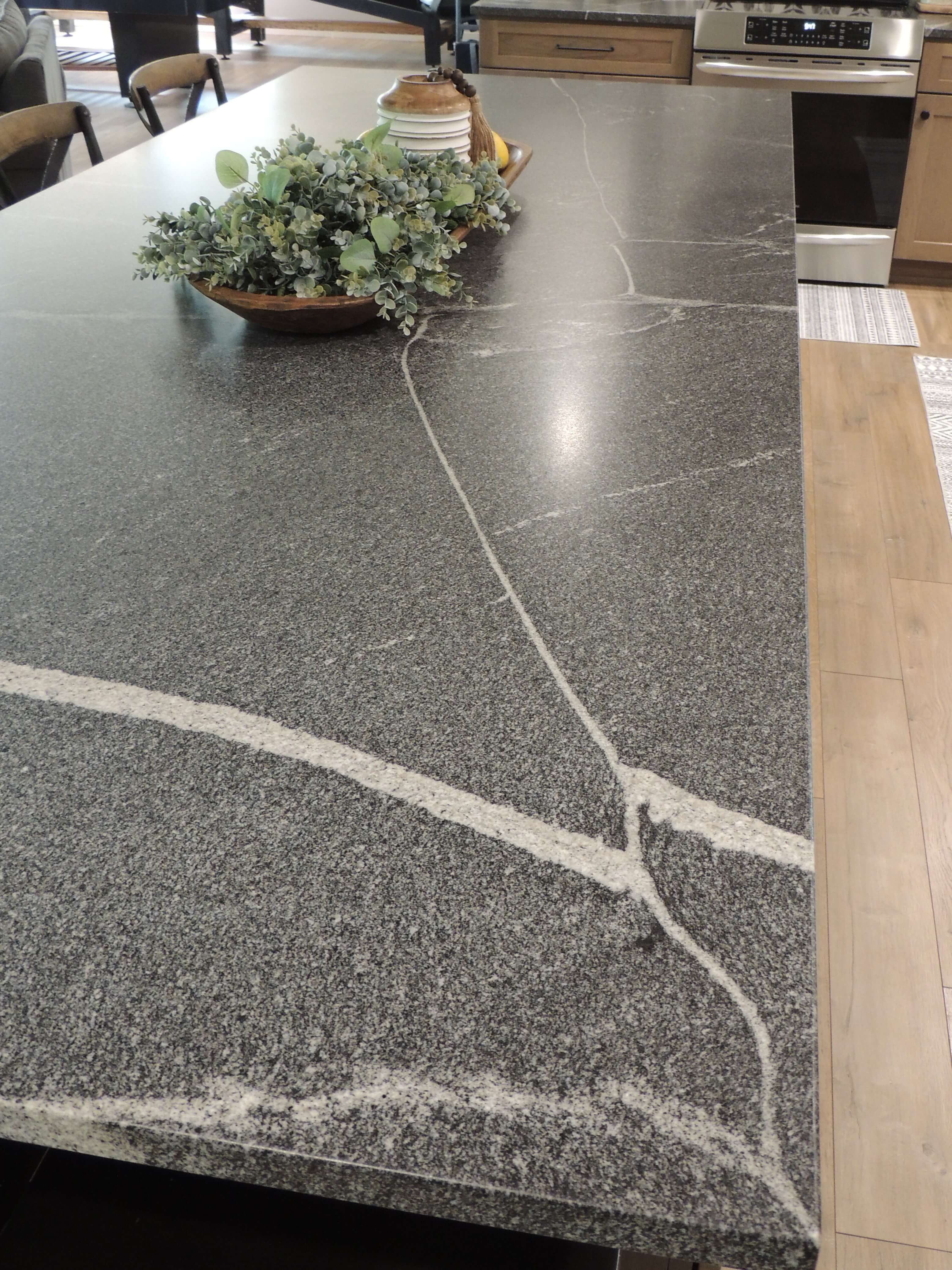 Take a look at the details in the kitchen island countertop with a dark gray, honed granite surface.