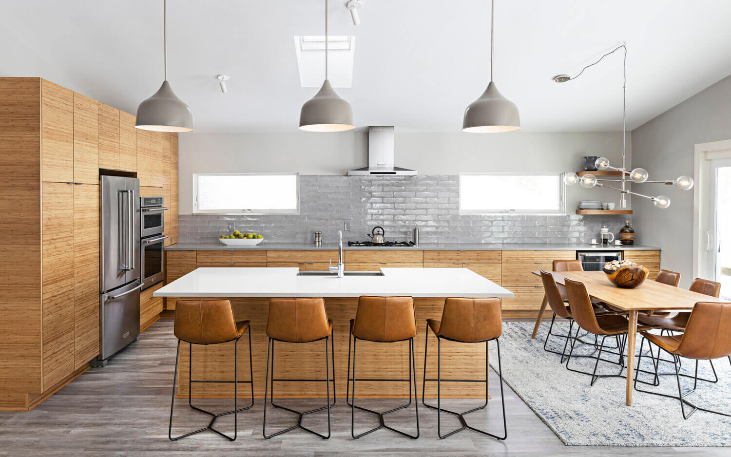 A beautiful kitchen with a light gray color palette contrasted by warm, natural bamboo cabinets with a modern & contemporary design style.