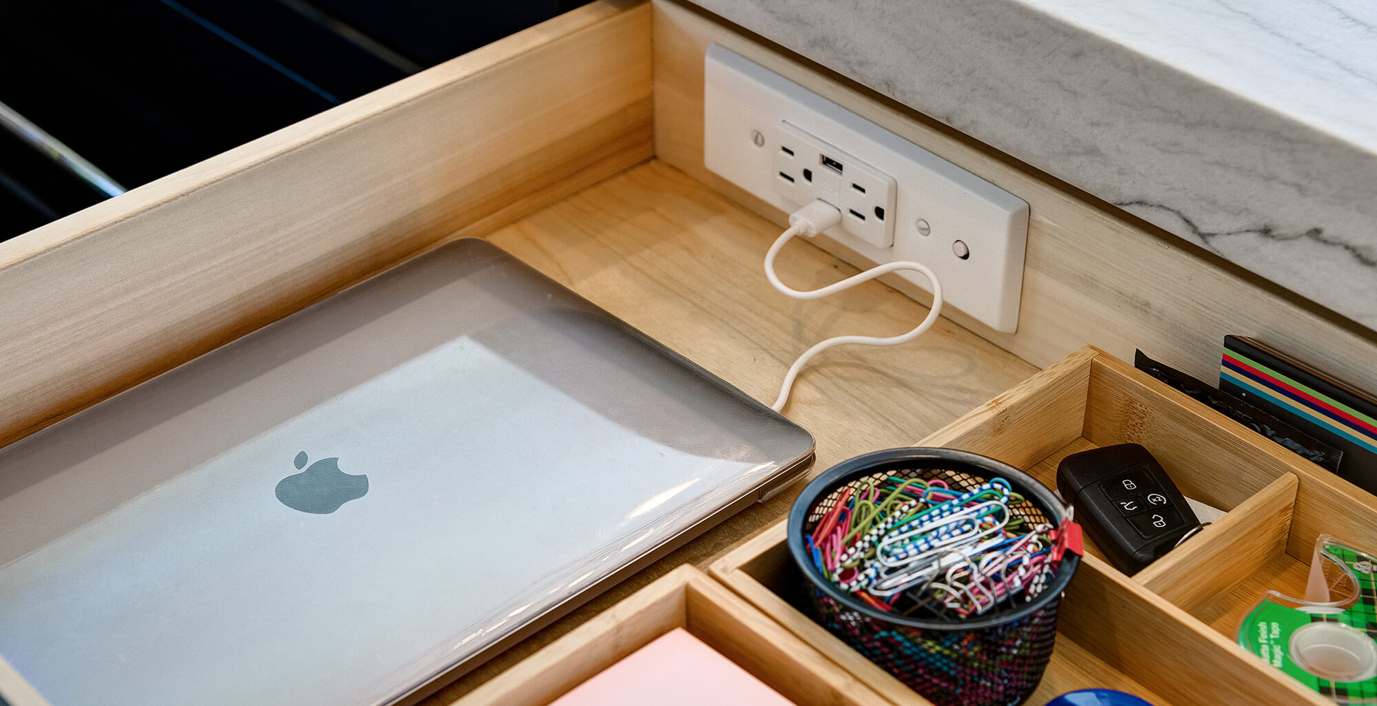 A cabinet drawer with a charging outlet inside the drawer for charging and powering electronic devices.