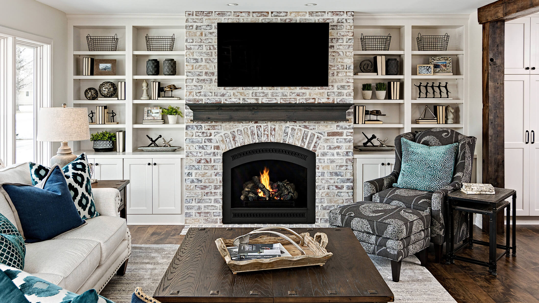 A stunning white paint and gray stained built-in entertainement center with a coordinating gray stained fireplace mantel.
