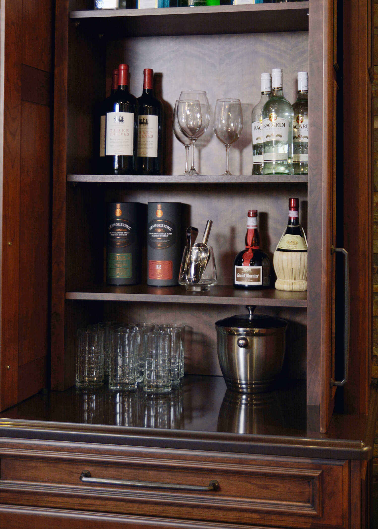 Cabinet pocket doors in a home entertainment center that hide a home bar workstation.