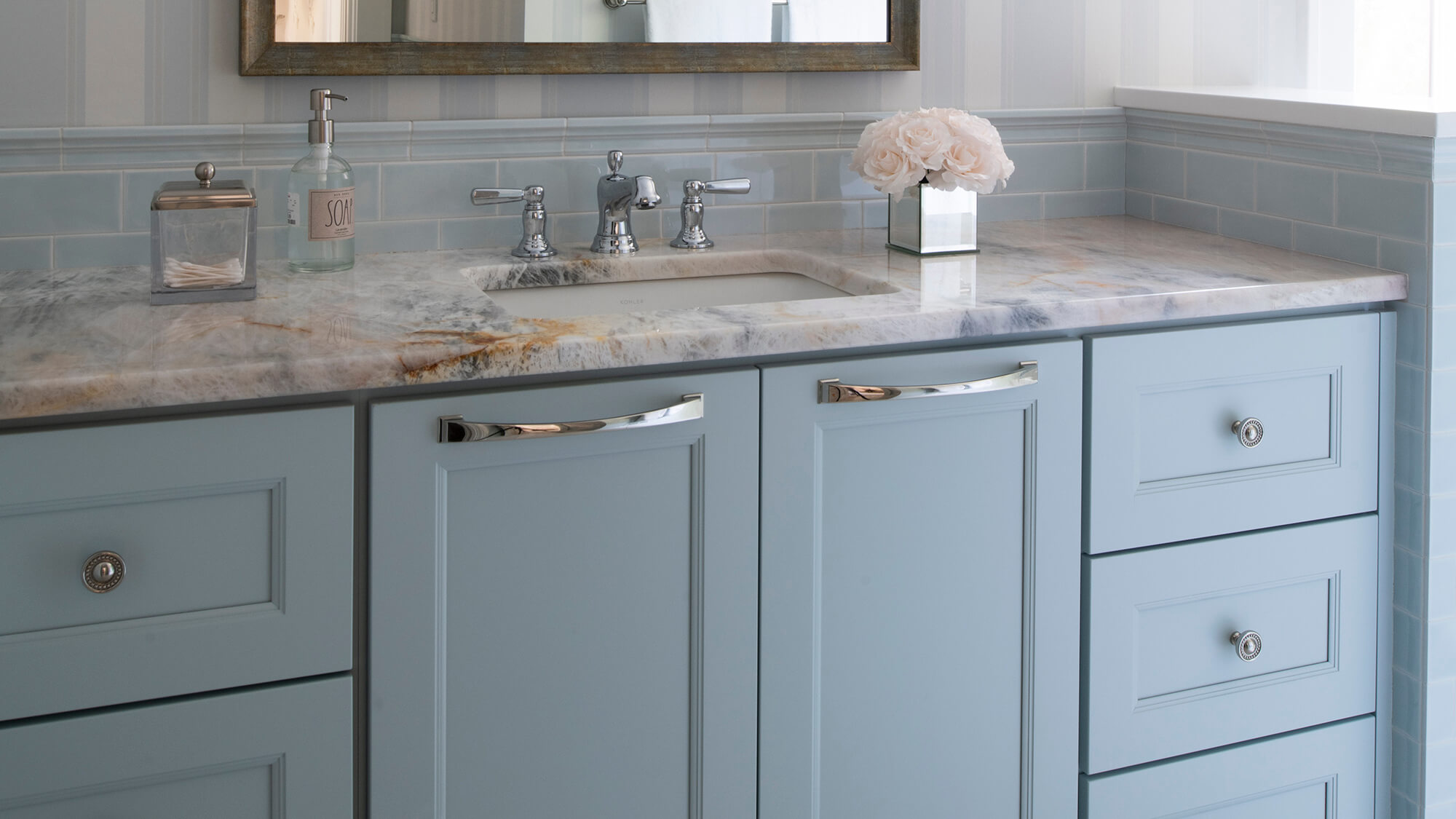 A soft, light baby blue bathroom vanity with an elegant flat panel cabinet door style.