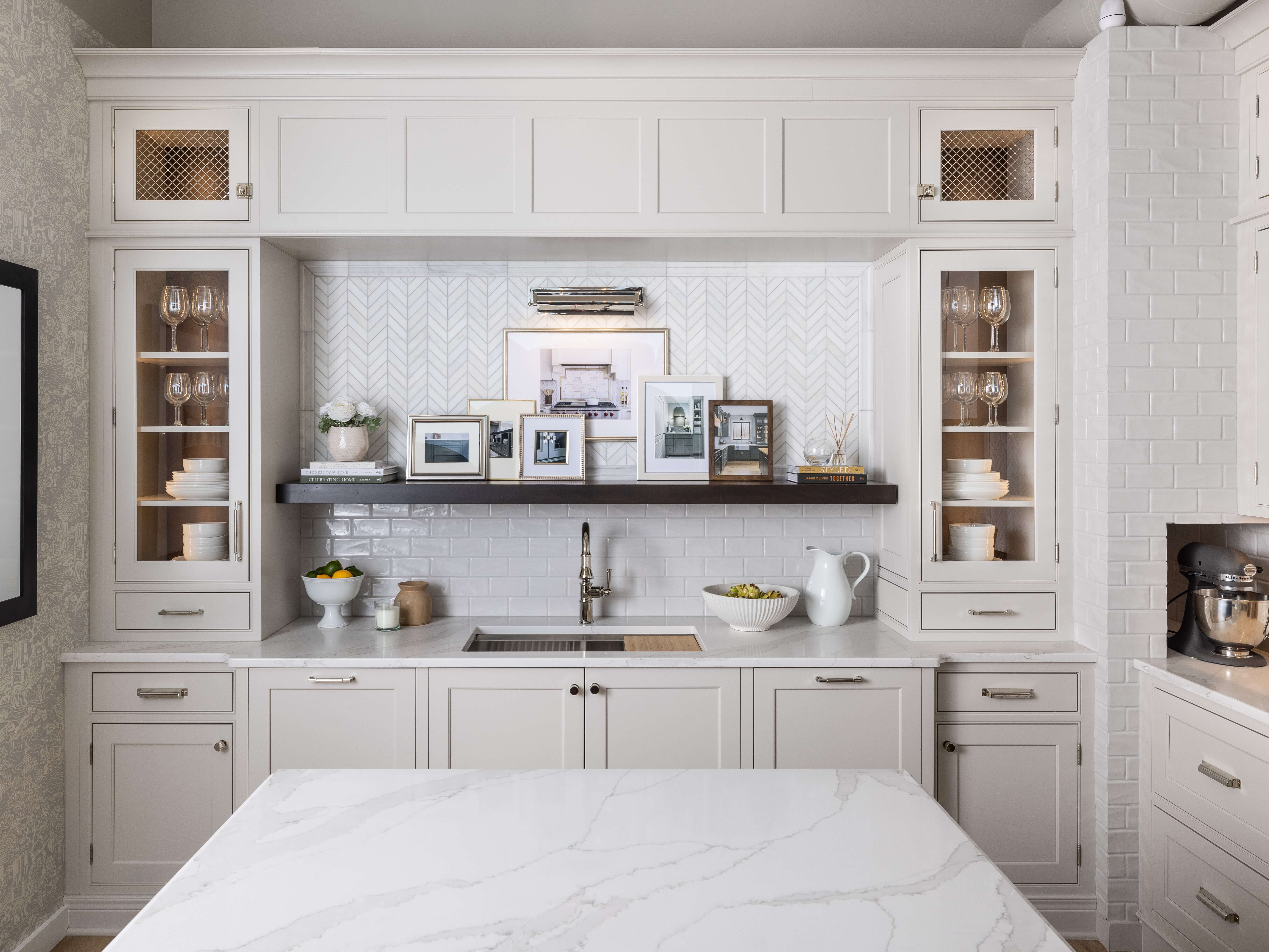 An all-white kitchen design with gentle, soft white painted cabinets in a trend-setting off-white hue.