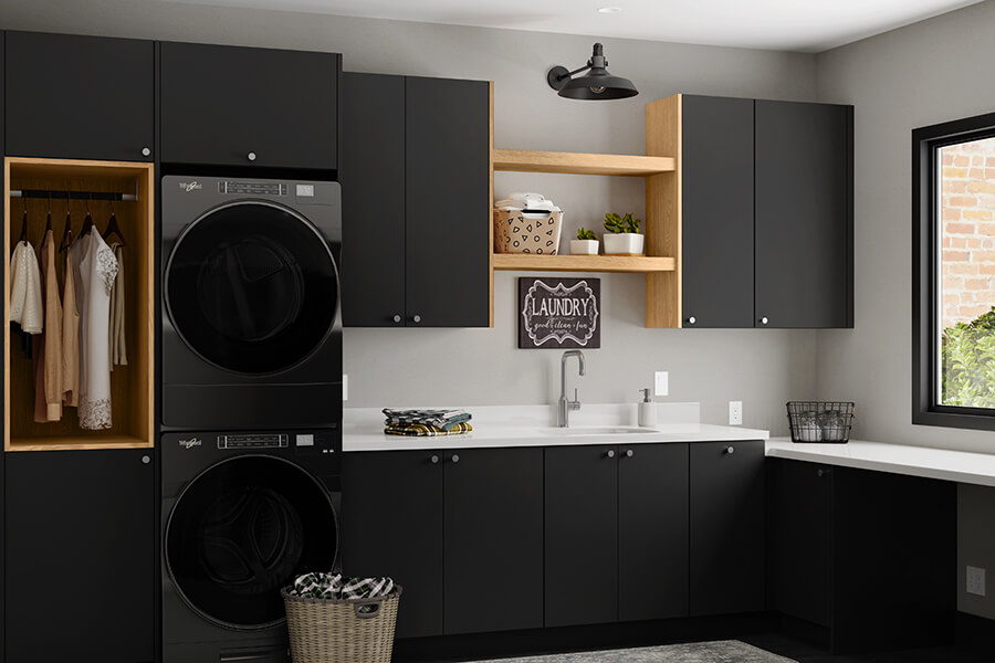 Sleek matte black cabinets with light, natural wood accents in a Scandi styled laundry room remodel.