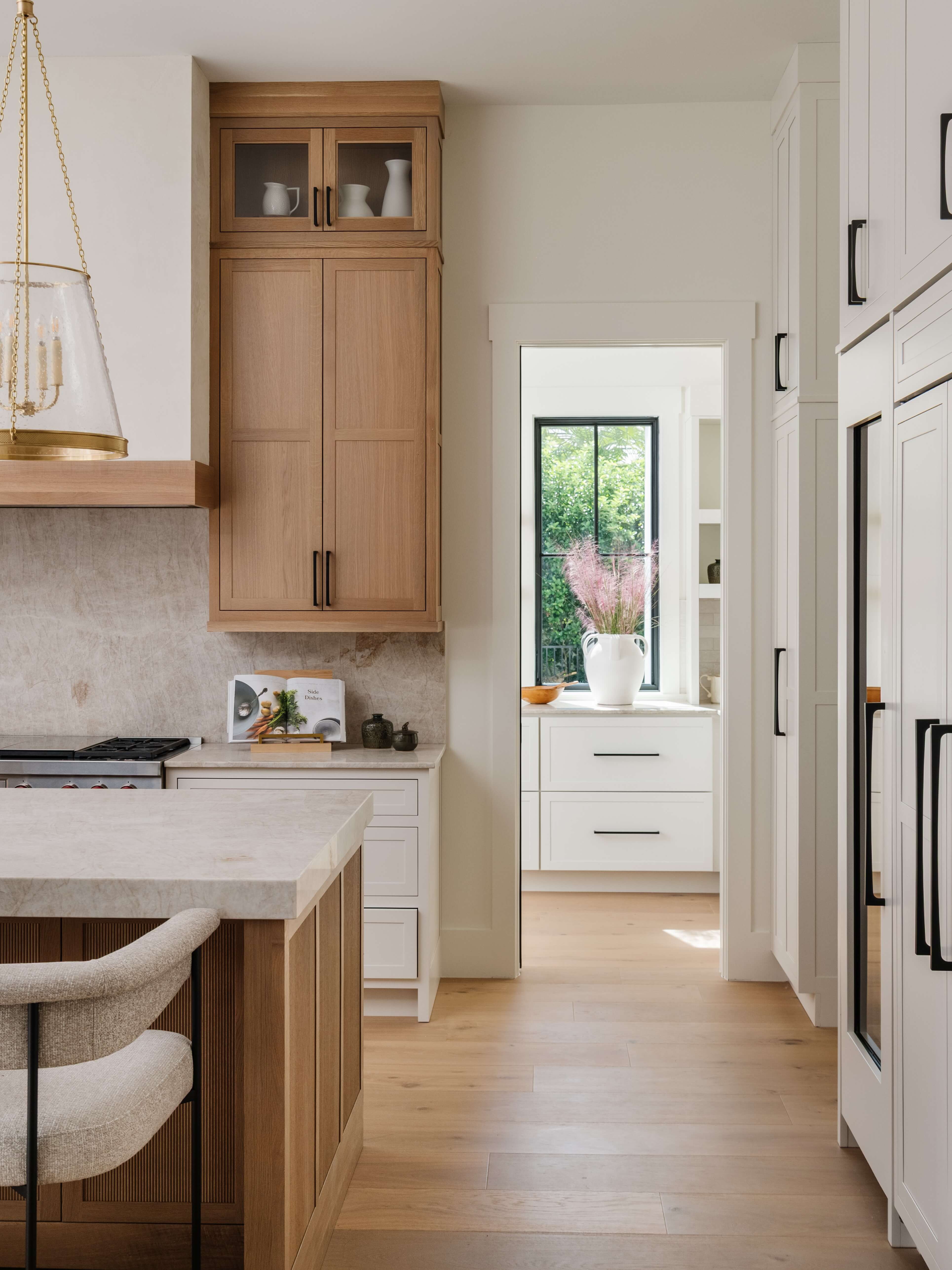 White painted cabinets and blonde stained quarter-sawn white oak cabinets come together in this beautiful kitchen design.
