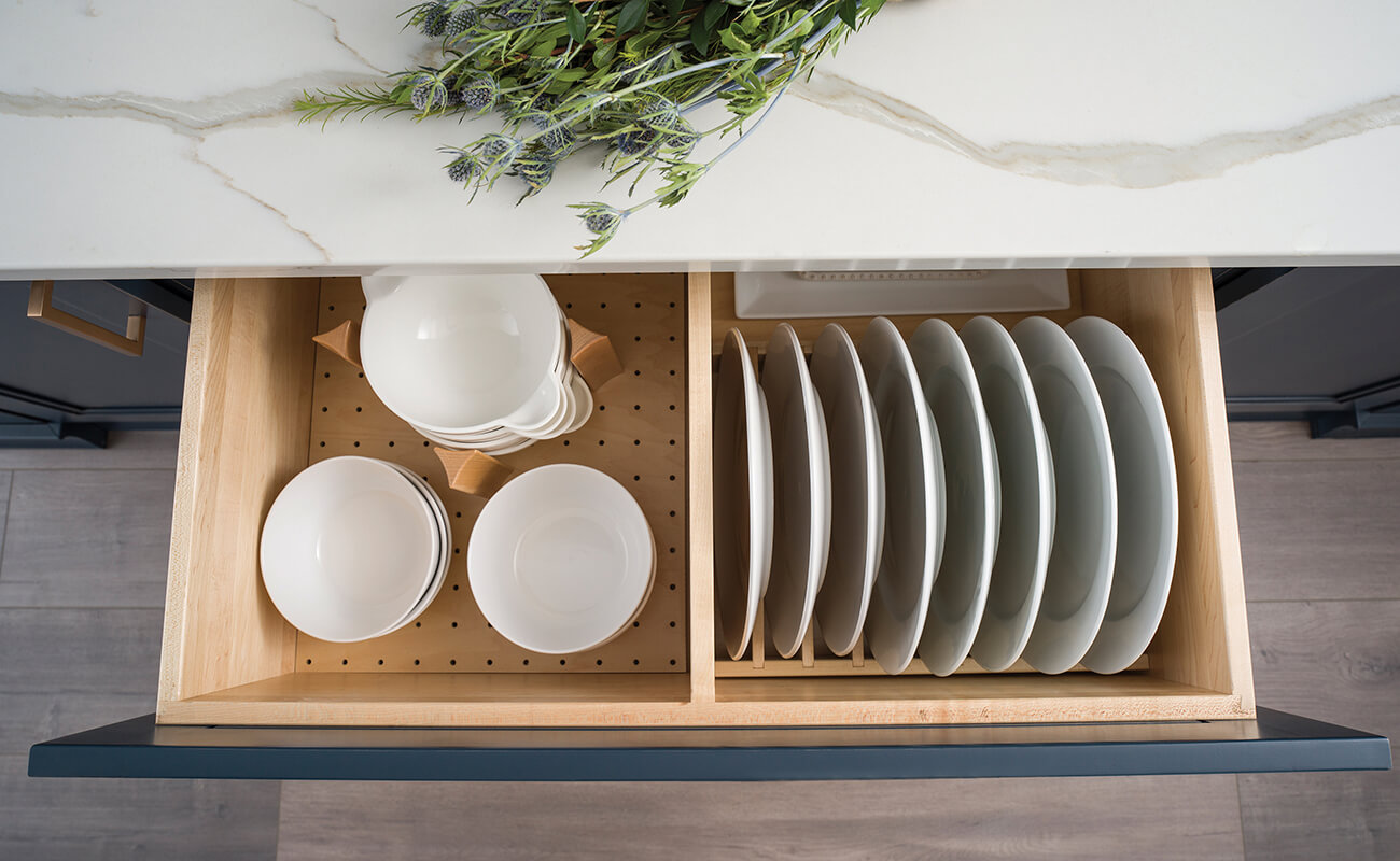 An organized drawer for dishware with a plate rack and dish stacking system.
