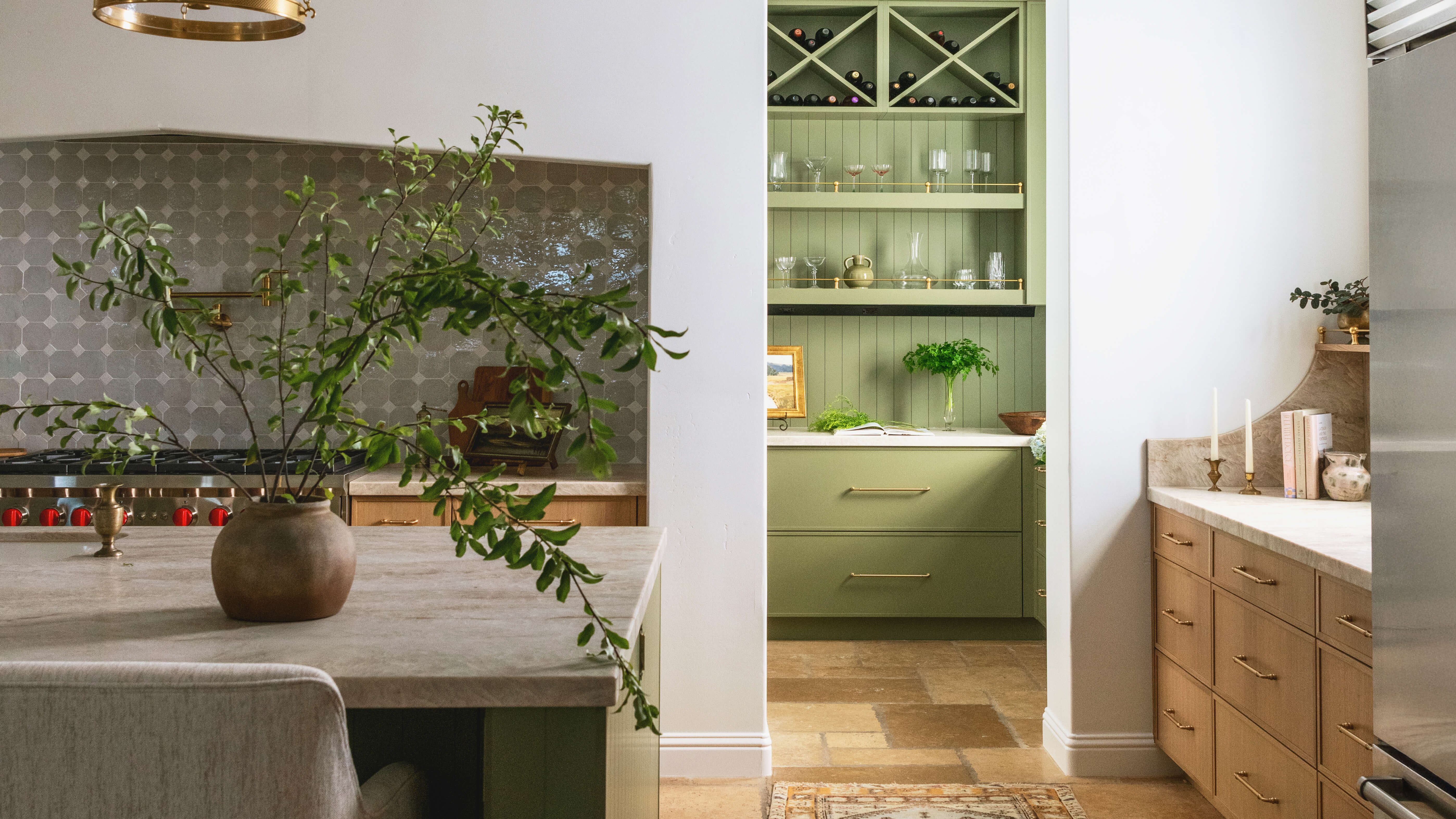 The gentle curved detail of the range alcove and the curved backsplash to the workstation on the right adds an organic feeling to the space.